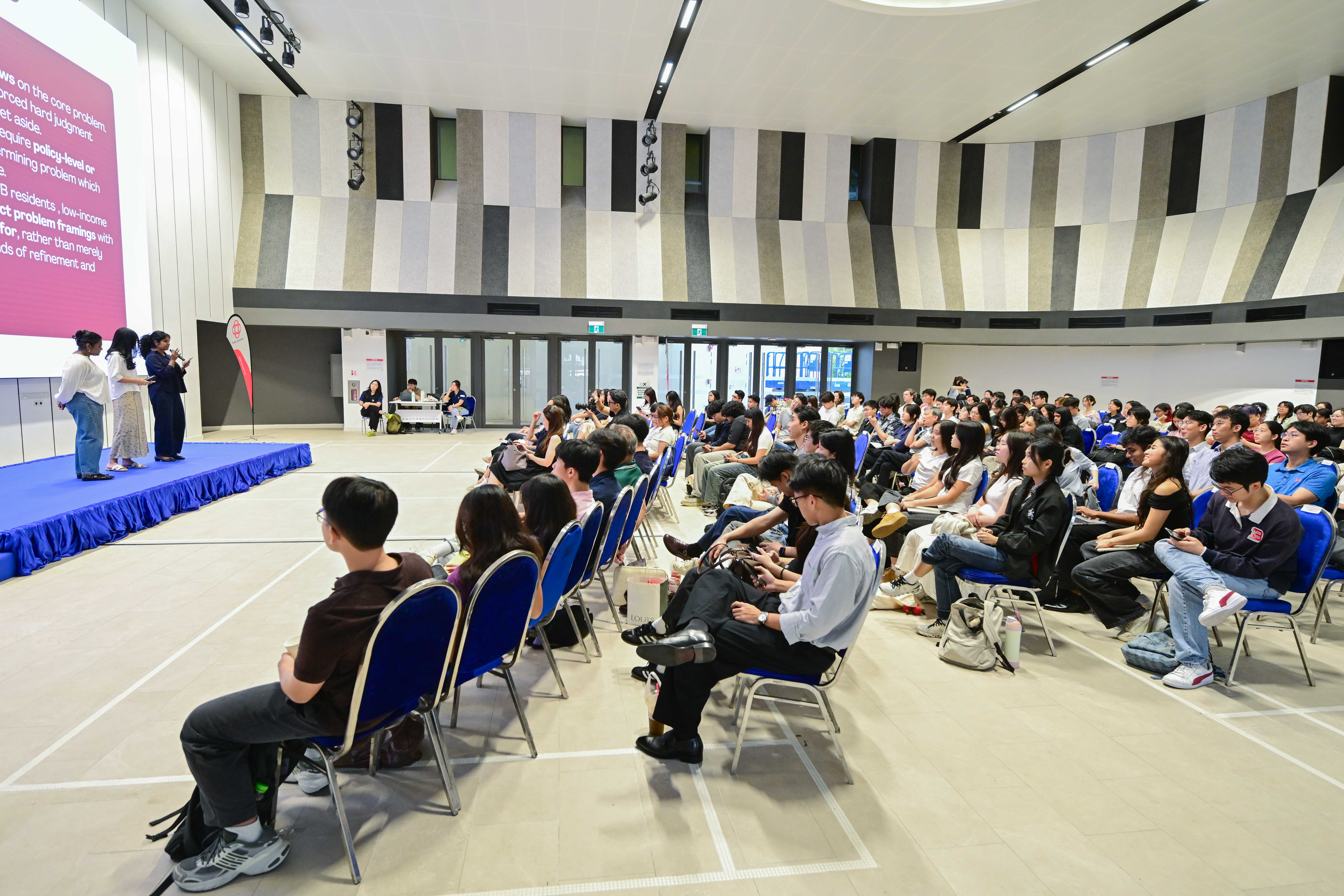Three students describing their problem statement to the audience